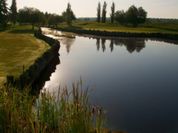 sun setting over water hazard at The Links at Spruce Grove