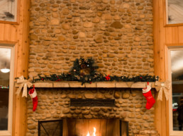 stone fireplace decorated for Christmas inside at The Links at Spruce Grove